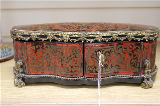 A boulle gilt metal mounted shaped rectangular casket, with lifting top and two doors, inlaid with brass scroll work, length 29cm